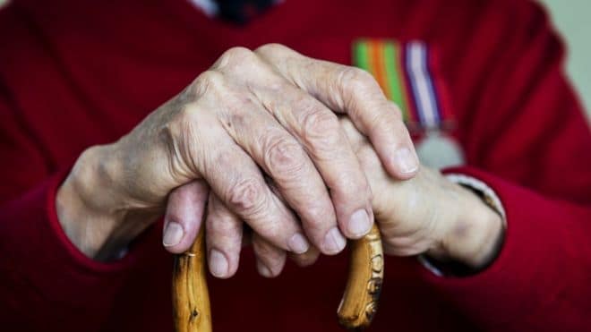 foto de maos idosas apiadas sobre uma bengala