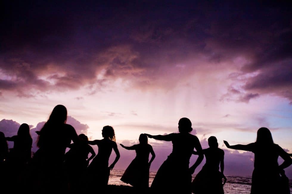 foto colorida com silhuetas conta o entardecer de dançarinas de hua hula